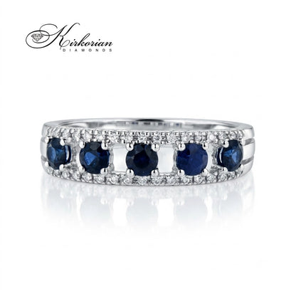 Детайлен близък план на пръстен RN32 от 18К бяло злато с ред от пет кръгли сини сапфира и фин диамантен ореол.